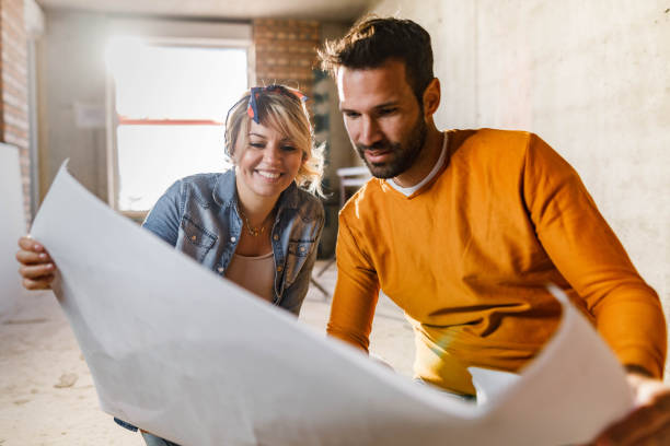 gelukkig paar dat plannen analyseert bij hun het renoveren flat. - verbouwing stockfoto's en -beelden